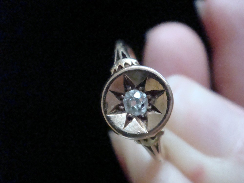 An 18ct yellow gold Victorian ring featuring a central starburst engraving with a single flush-set diamond. View V