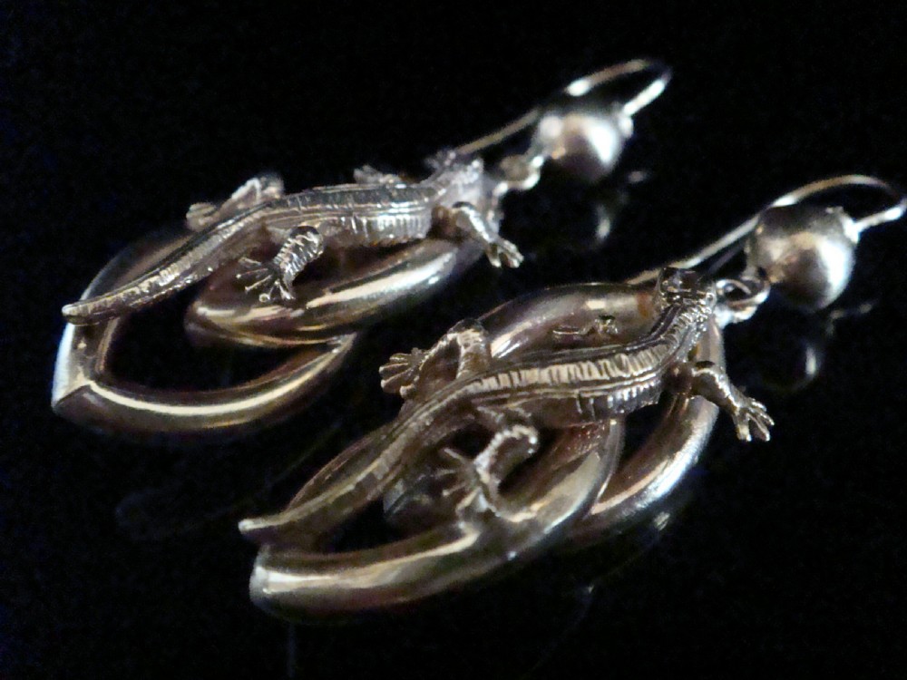 A pair of 9ct yellow gold drop earrings featuring sculpted three-dimensional lizards mounted over curved oval loops suspended from sphere studs.