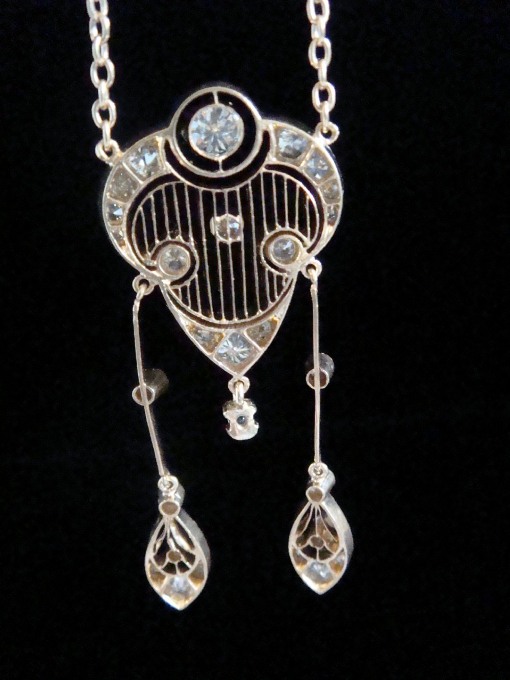 An ornate Victorian yellow gold pendant necklace set with round diamonds and black enamel accents, featuring two hanging diamond drop elements. View IV