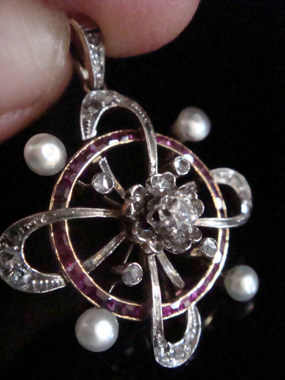 An 18ct gold Victorian openwork pendant set with a central diamond, four natural pearls, calibre-cut rubies, and rose-cut diamonds. View II