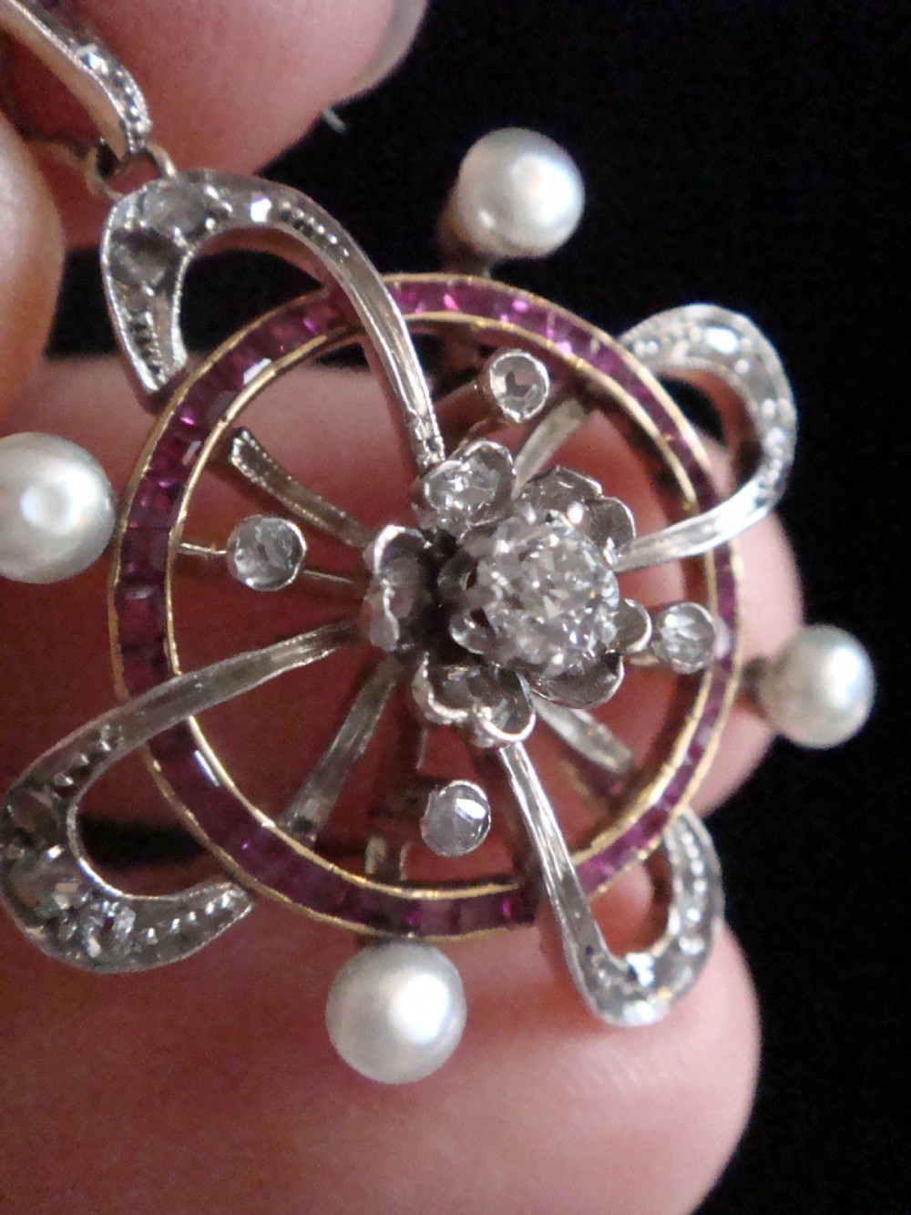 An 18ct gold Victorian openwork pendant set with a central diamond, four natural pearls, calibre-cut rubies, and rose-cut diamonds. View VII