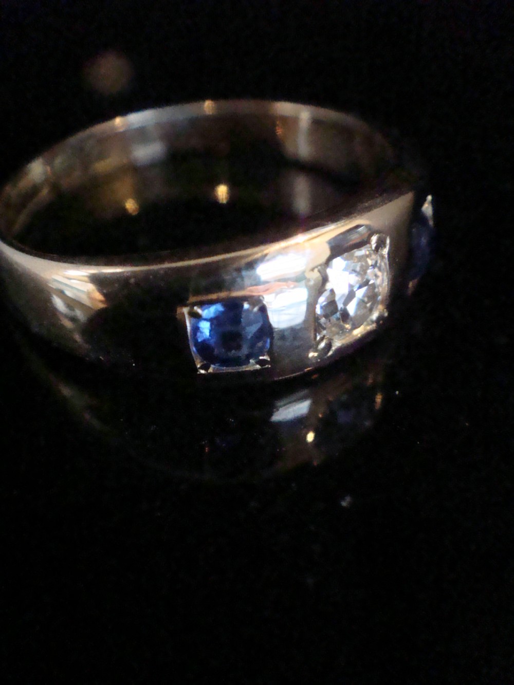 An antique 18ct yellow gold gypsy ring set with a central old cut diamond flanked by two round blue sapphires flush within the band. View III