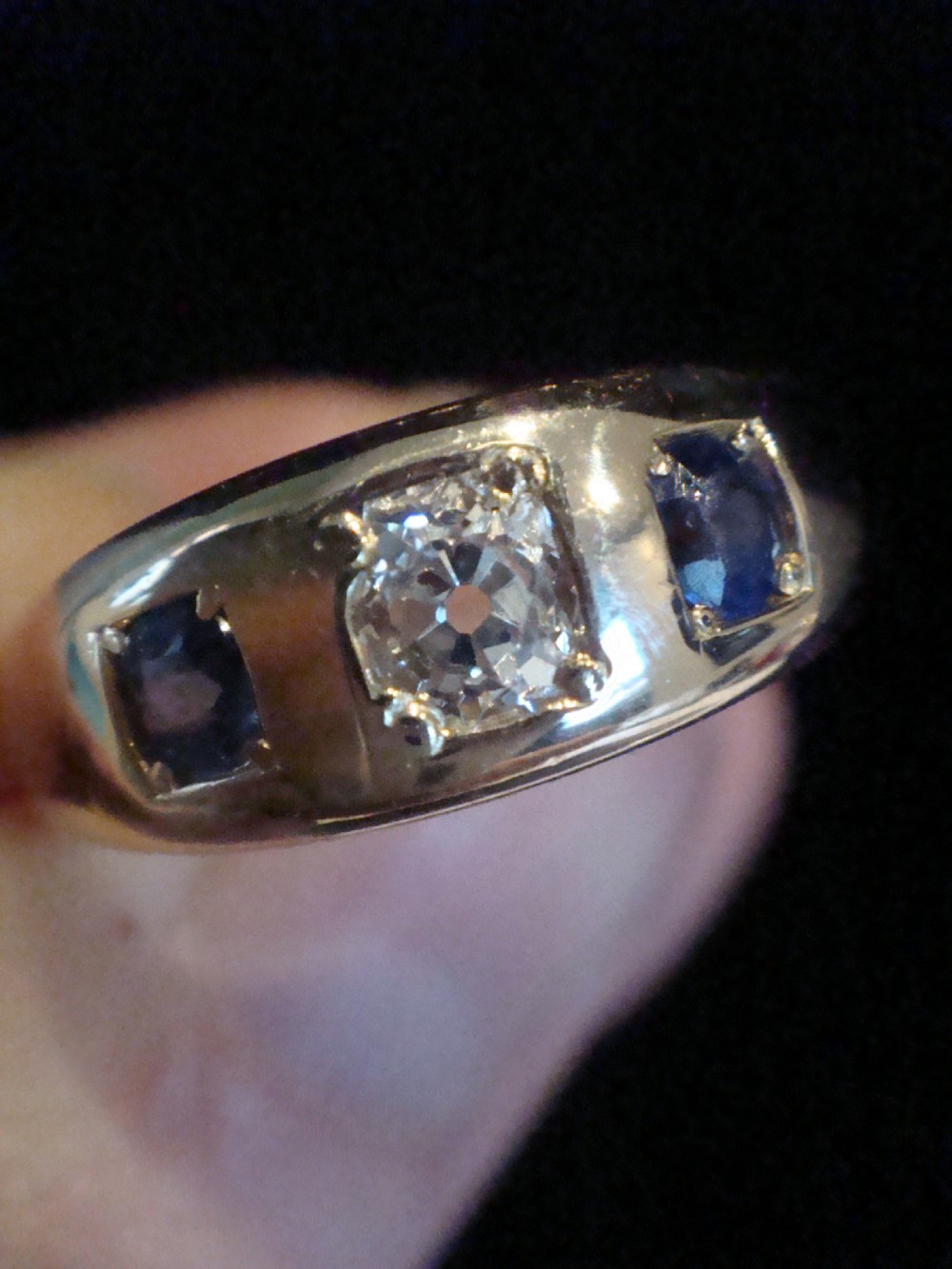 An antique 18ct yellow gold gypsy ring set with a central old cut diamond flanked by two round blue sapphires flush within the band. View IV