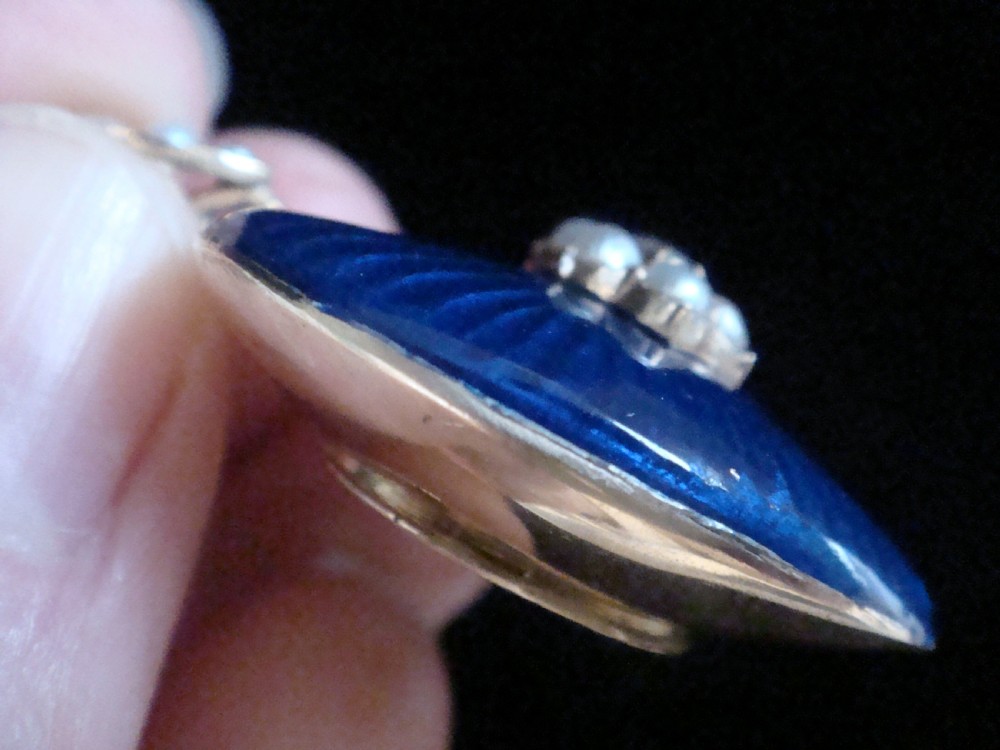 A Victorian heart-shaped pendant in cobalt blue guilloche enamel, accented by a central seed pearl and diamond star motif with a pearl-set gold bail. View III