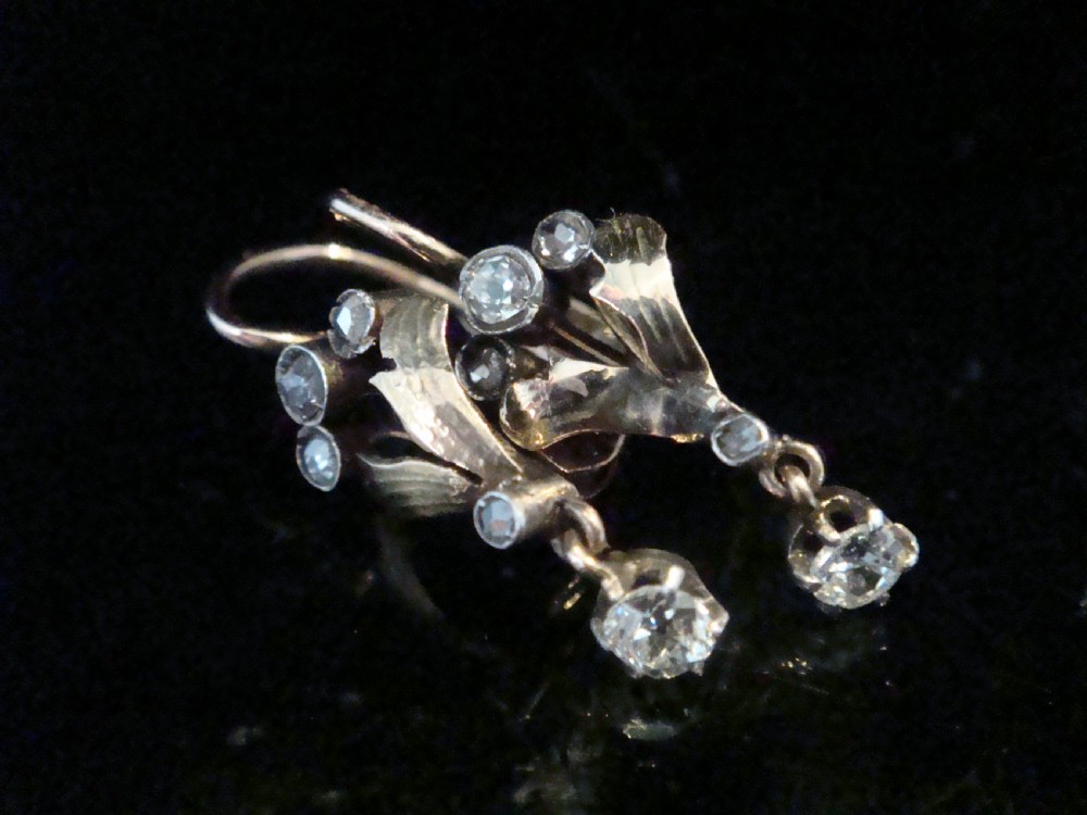 A pair of French Edwardian 18ct yellow gold and platinum drop earrings with leaf motifs, set with rose cut diamonds and suspended round diamond drops.