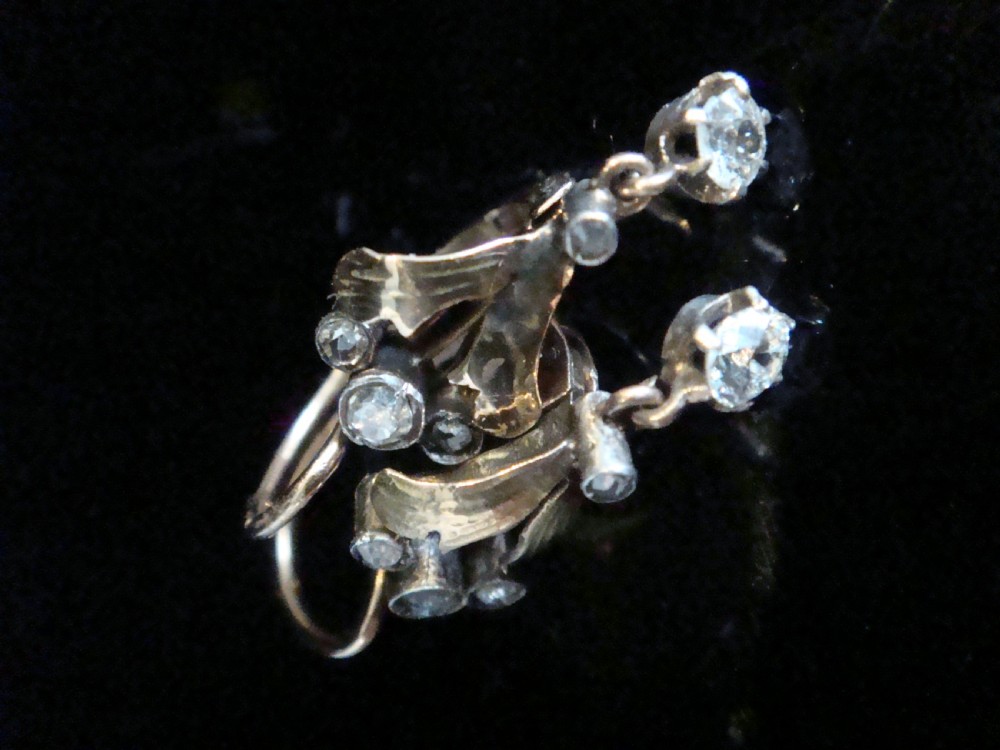 A pair of French Edwardian 18ct yellow gold and platinum drop earrings with leaf motifs, set with rose cut diamonds and suspended round diamond drops. View II