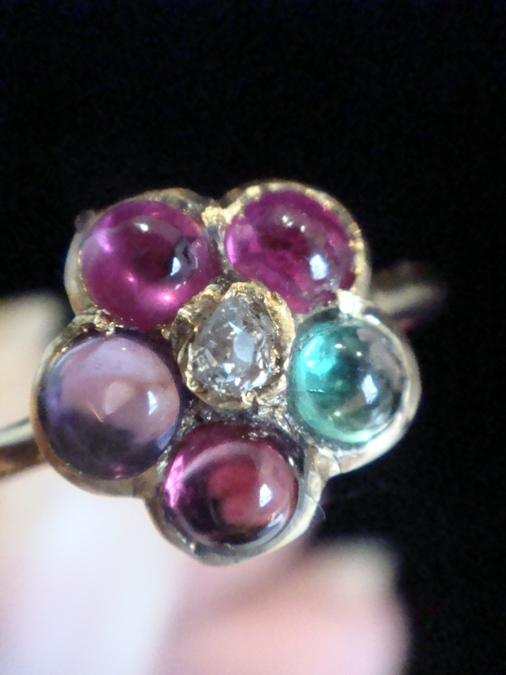 A Victorian 15ct gold flower cluster ring set with cabochon gemstones surrounding a central diamond. View III