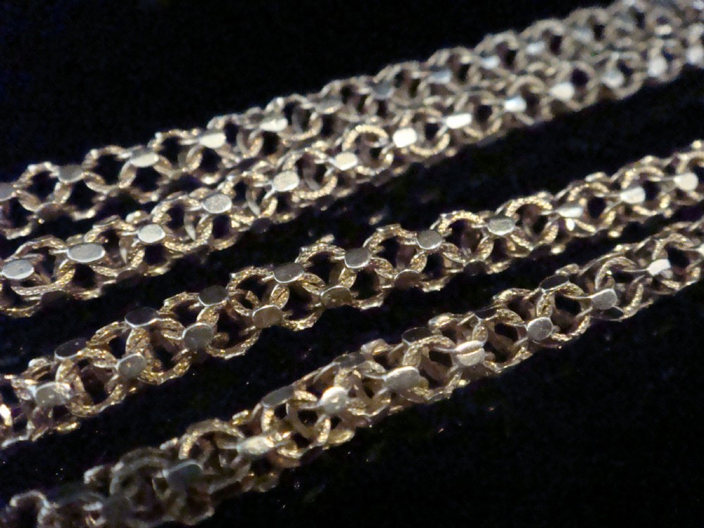 A close-up view of a Victorian 9ct yellow gold woven link chain featuring a dog clip fastener. View II