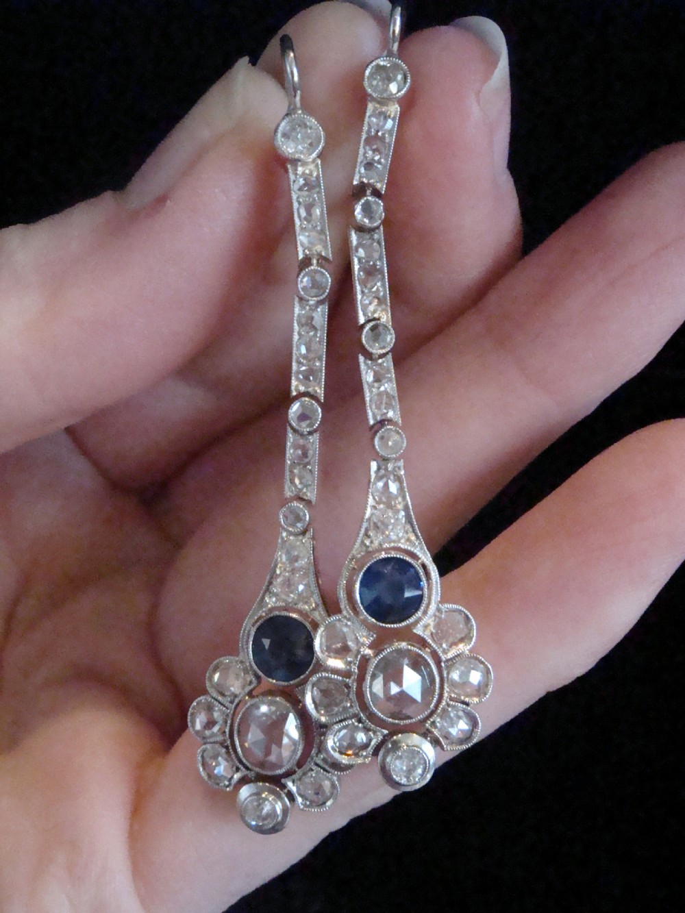A pair of Edwardian drop earrings set in platinum featuring blue sapphires and old cut diamond floral clusters. View V