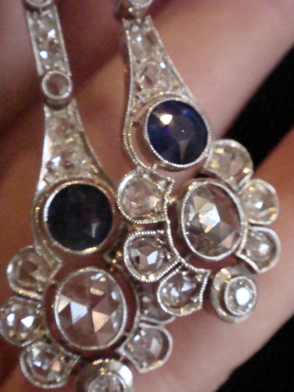 A pair of Edwardian drop earrings set in platinum featuring blue sapphires and old cut diamond floral clusters. View VI
