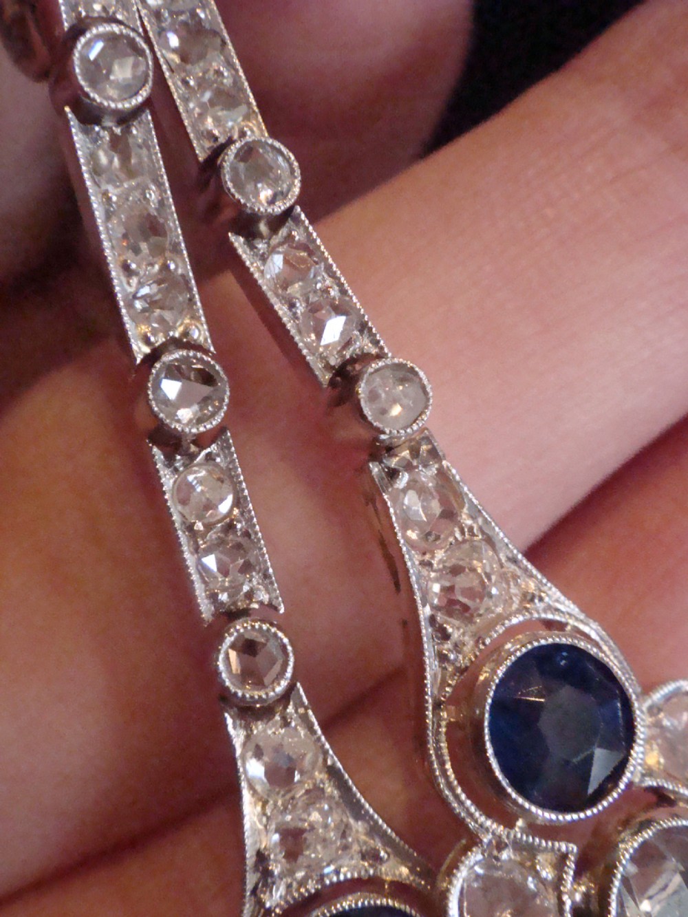 A pair of Edwardian drop earrings set in platinum featuring blue sapphires and old cut diamond floral clusters. View VIII