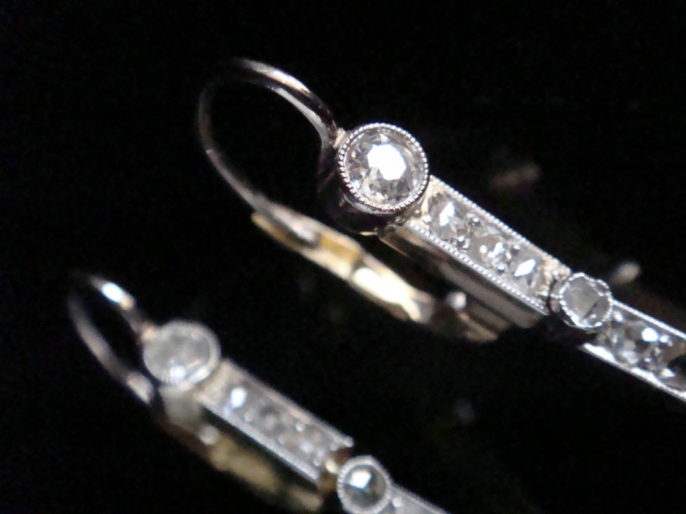 A pair of Edwardian drop earrings set in platinum featuring blue sapphires and old cut diamond floral clusters. View X