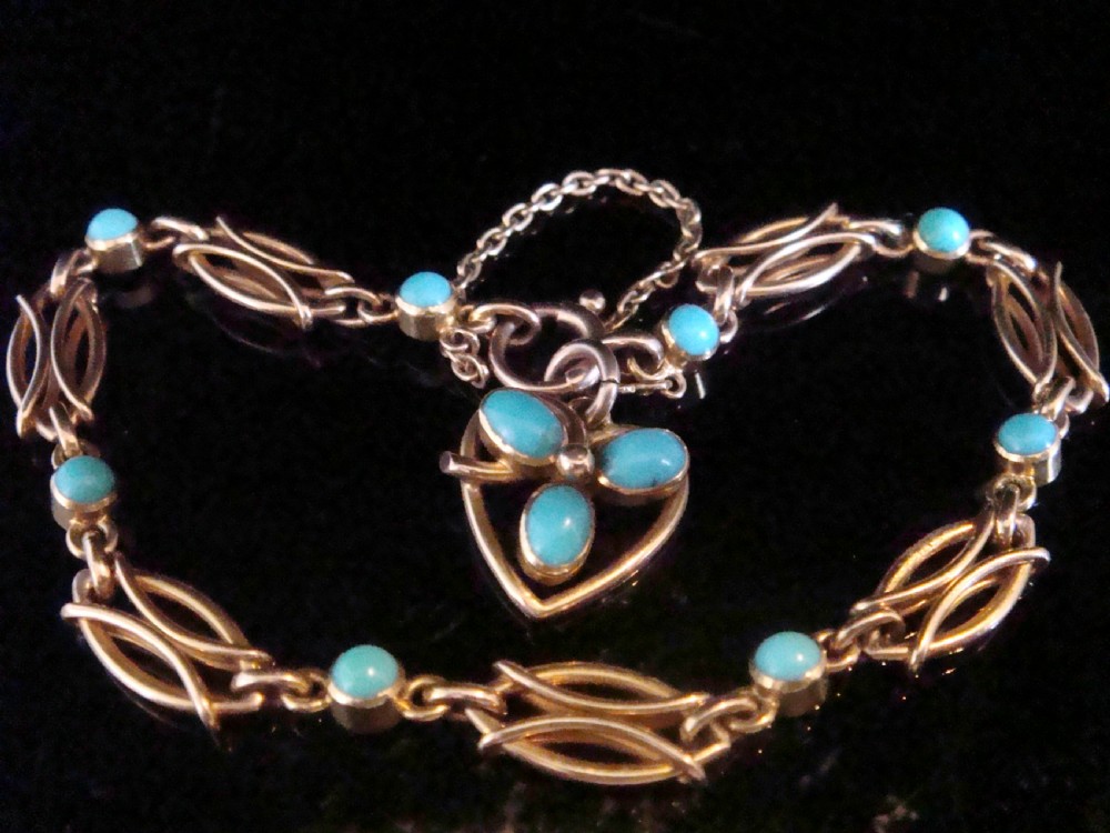 An Edwardian 15ct gold link bracelet featuring oval cabochon turquoise stones and a central heart-shaped turquoise pendant.