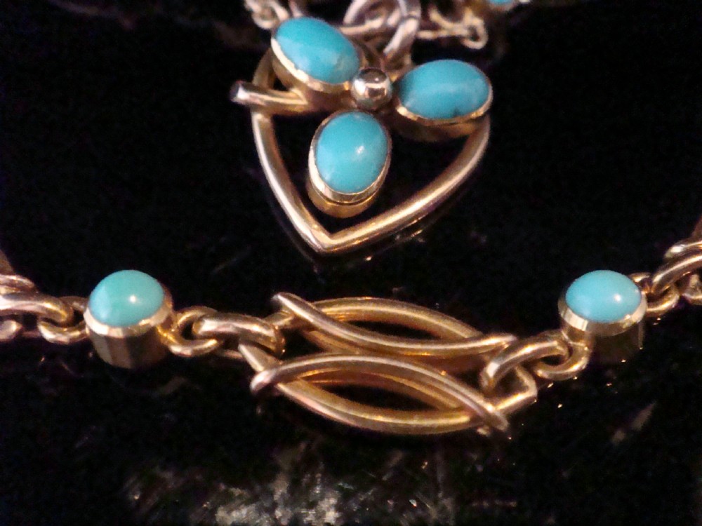 An Edwardian 15ct gold link bracelet featuring oval cabochon turquoise stones and a central heart-shaped turquoise pendant. View II
