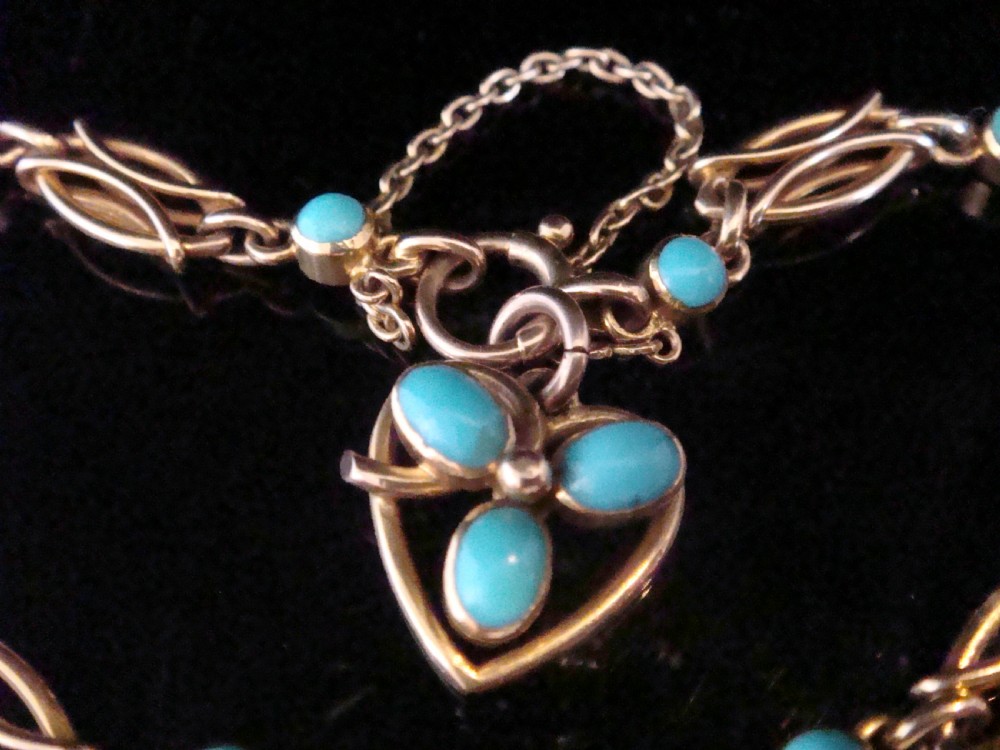 An Edwardian 15ct gold link bracelet featuring oval cabochon turquoise stones and a central heart-shaped turquoise pendant. View III
