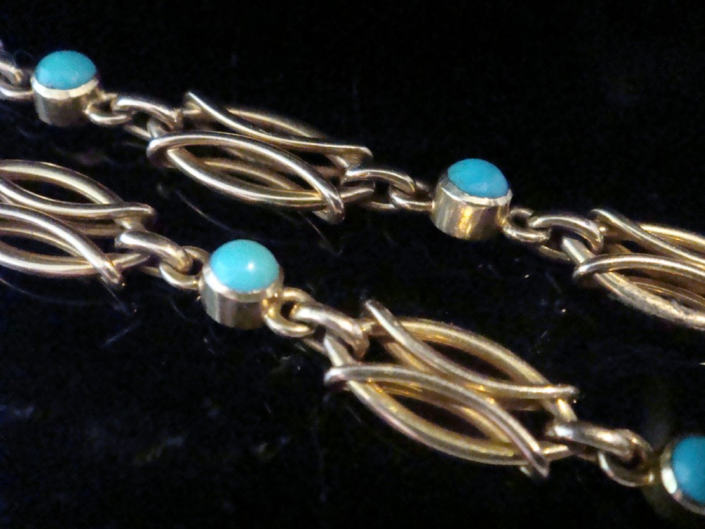 An Edwardian 15ct gold link bracelet featuring oval cabochon turquoise stones and a central heart-shaped turquoise pendant. View IV