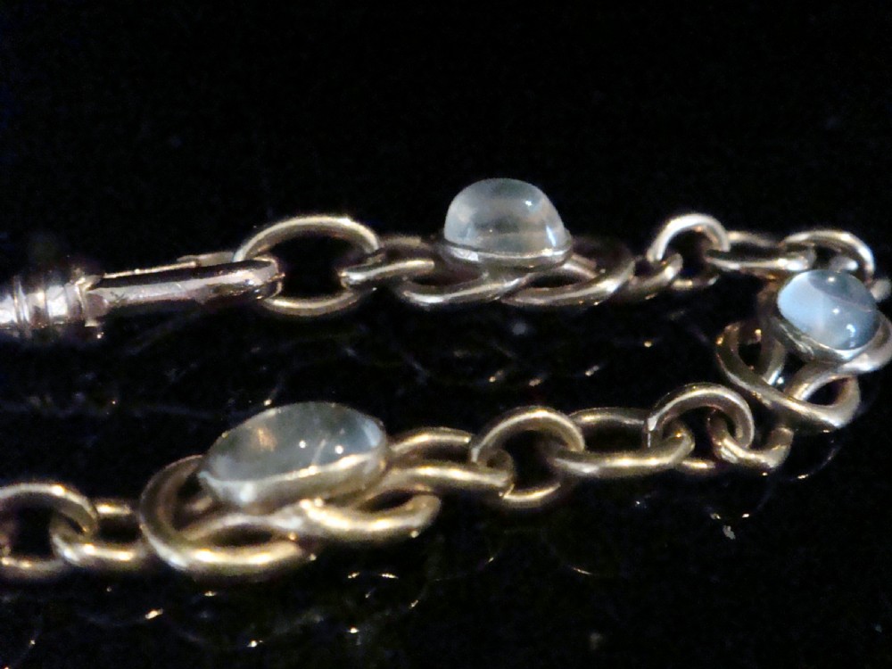 An Edwardian 9ct rose gold chain bracelet featuring lovers knot links set with oval moonstone cabochons. View III