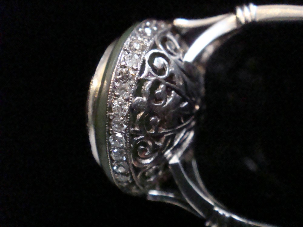 Circular Art Deco platinum target ring featuring a central old cut diamond surrounded by green chalcedony and milgrain pierced detailing. View III
