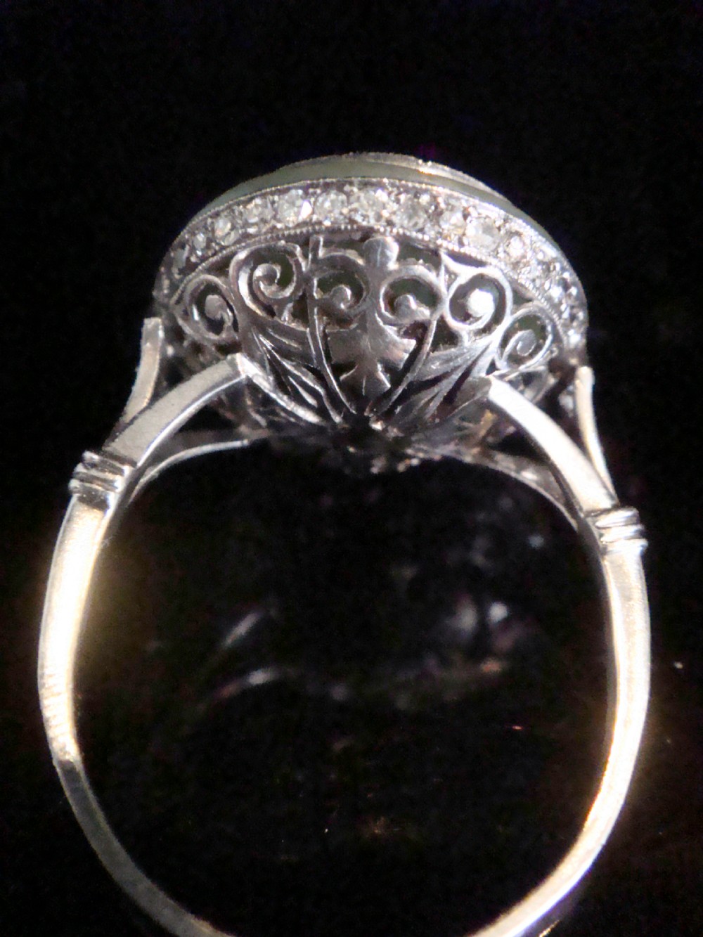 Circular Art Deco platinum target ring featuring a central old cut diamond surrounded by green chalcedony and milgrain pierced detailing. View VI