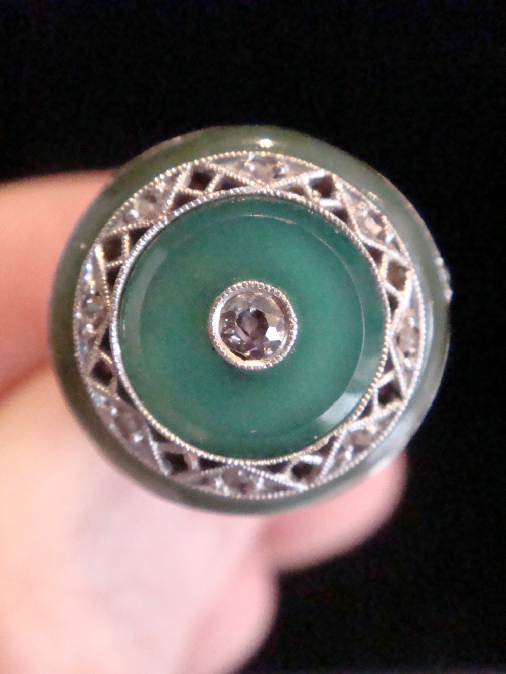 Circular Art Deco platinum target ring featuring a central old cut diamond surrounded by green chalcedony and milgrain pierced detailing. View VII