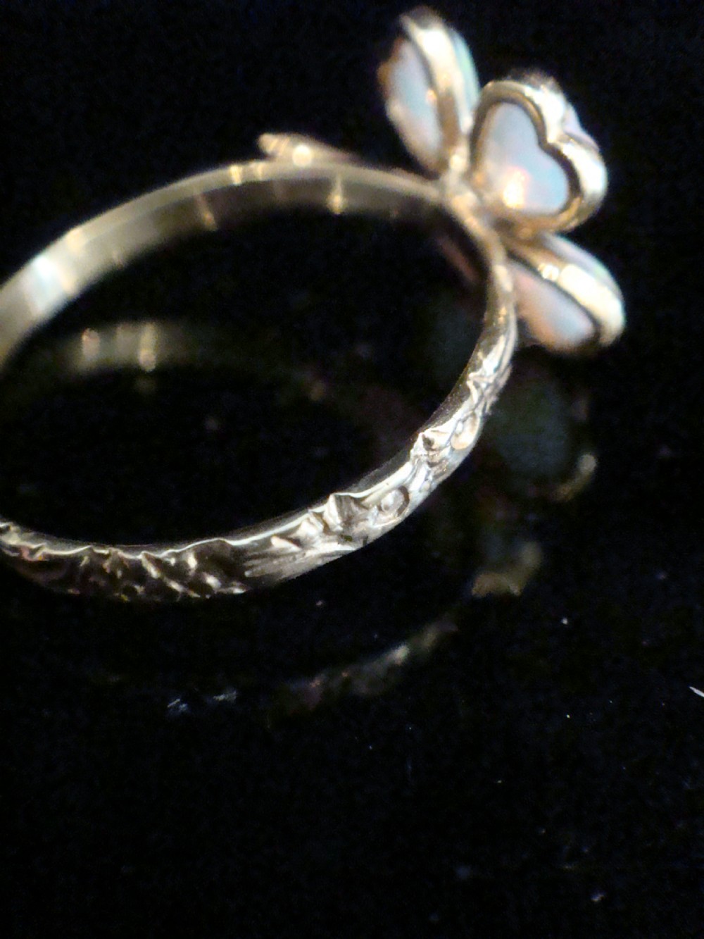 An Edwardian 18ct yellow gold ring featuring a four-leaf clover design composed of four heart-shaped opals surrounding a central round diamond. View IV