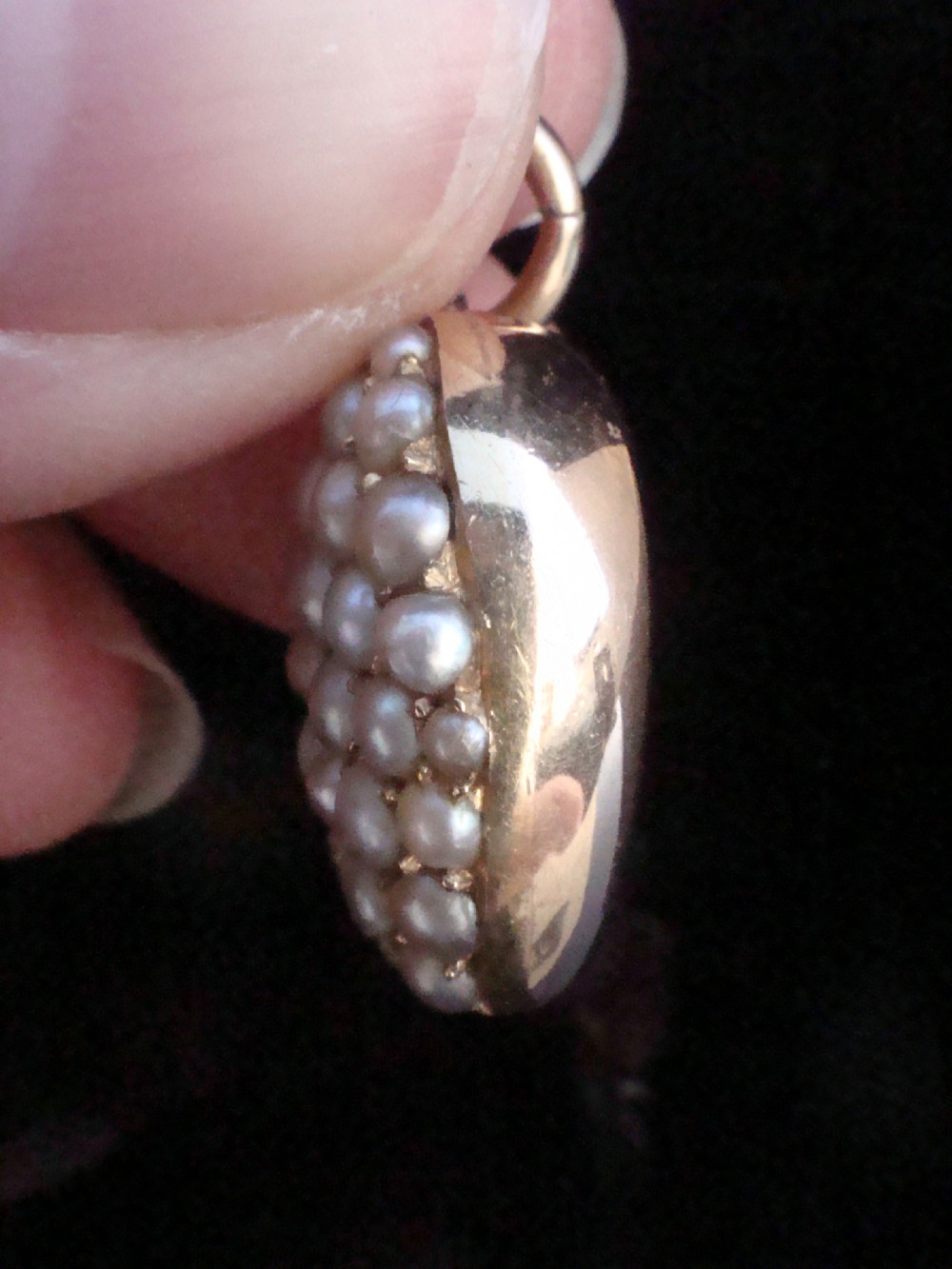 A Victorian heart-shaped 15ct yellow gold pendant encrusted with seed pearls around a single central emerald. View III