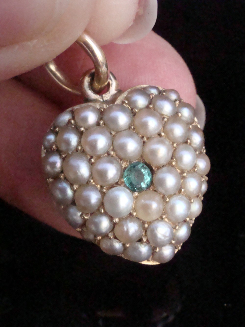 A Victorian heart-shaped 15ct yellow gold pendant encrusted with seed pearls around a single central emerald. View V