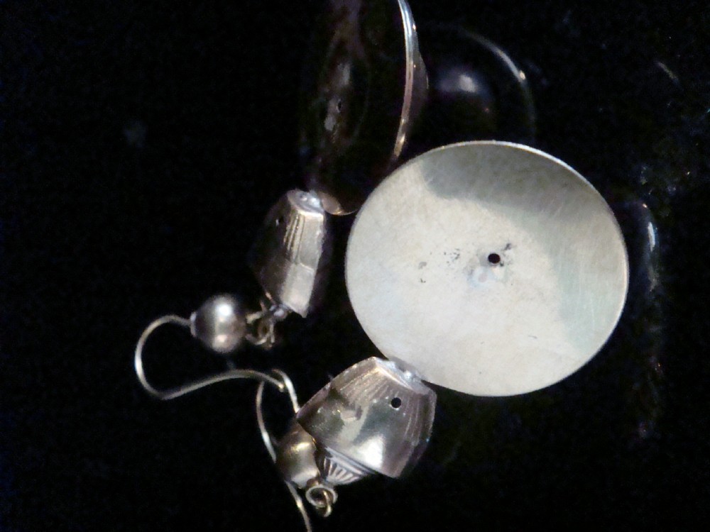 A pair of Victorian 9ct rose and yellow gold drop earrings featuring circular domed central motifs suspended from decorative top sections and shepherd hooks. View V