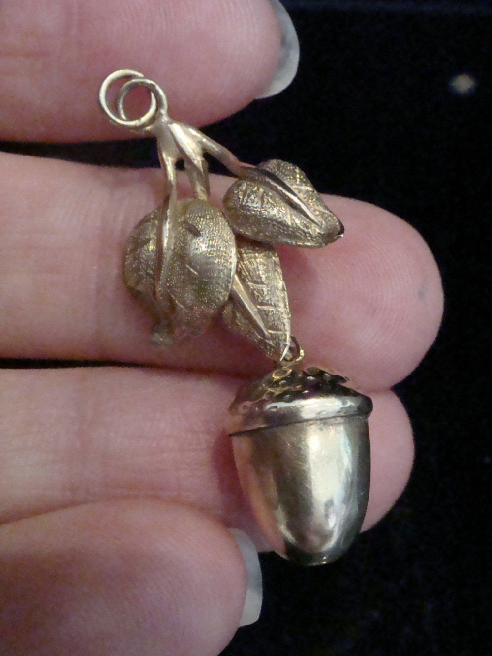 An Edwardian 9ct yellow gold drop pendant featuring textured oak leaves and a hanging acorn motif.