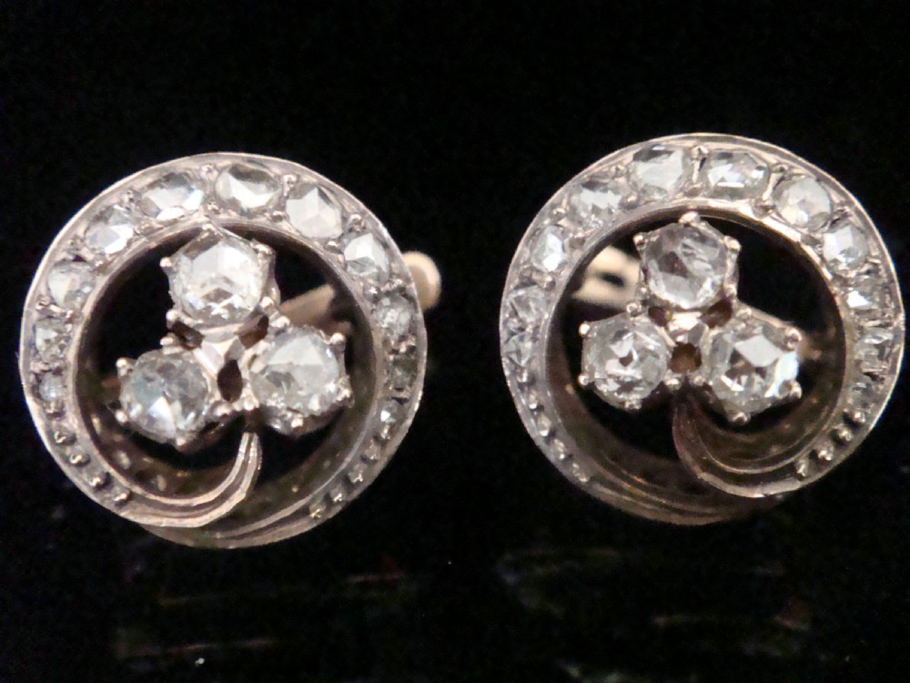Pair of circular French Art Nouveau stud earrings featuring a central rose-cut diamond three-leaf clover framed by a diamond halo.