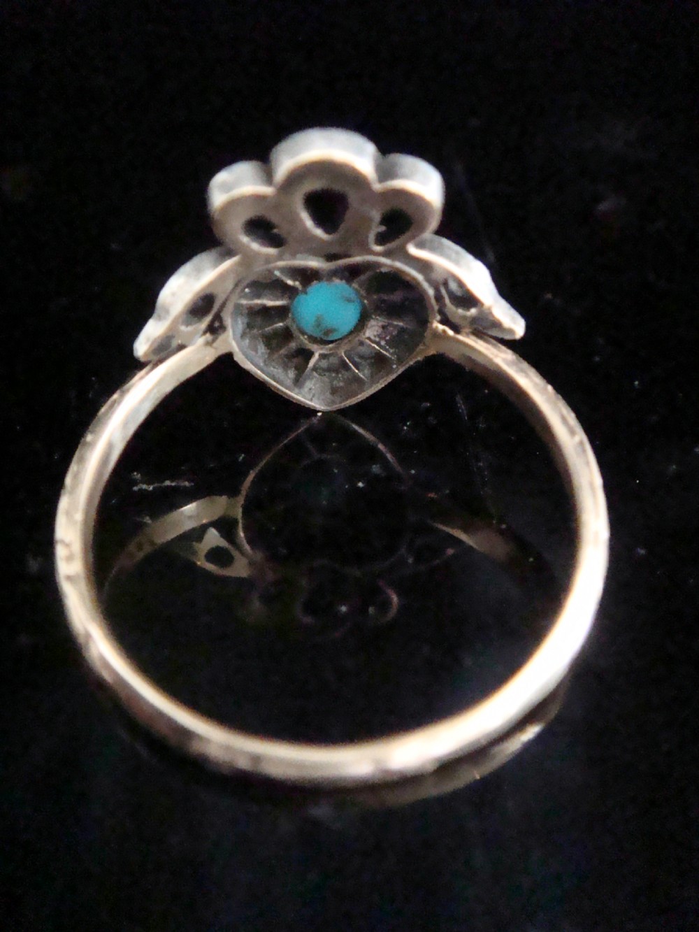 An antique heart-shaped ring featuring a central turquoise cabochon framed by rose-cut diamonds and topped with a diamond ribbon bow motif on a thin gold band. View IV