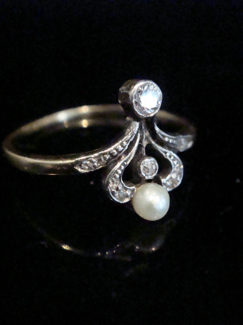 A French Edwardian 18ct gold and platinum ring featuring a central natural pearl set below a tiara motif with old-cut diamonds. View II