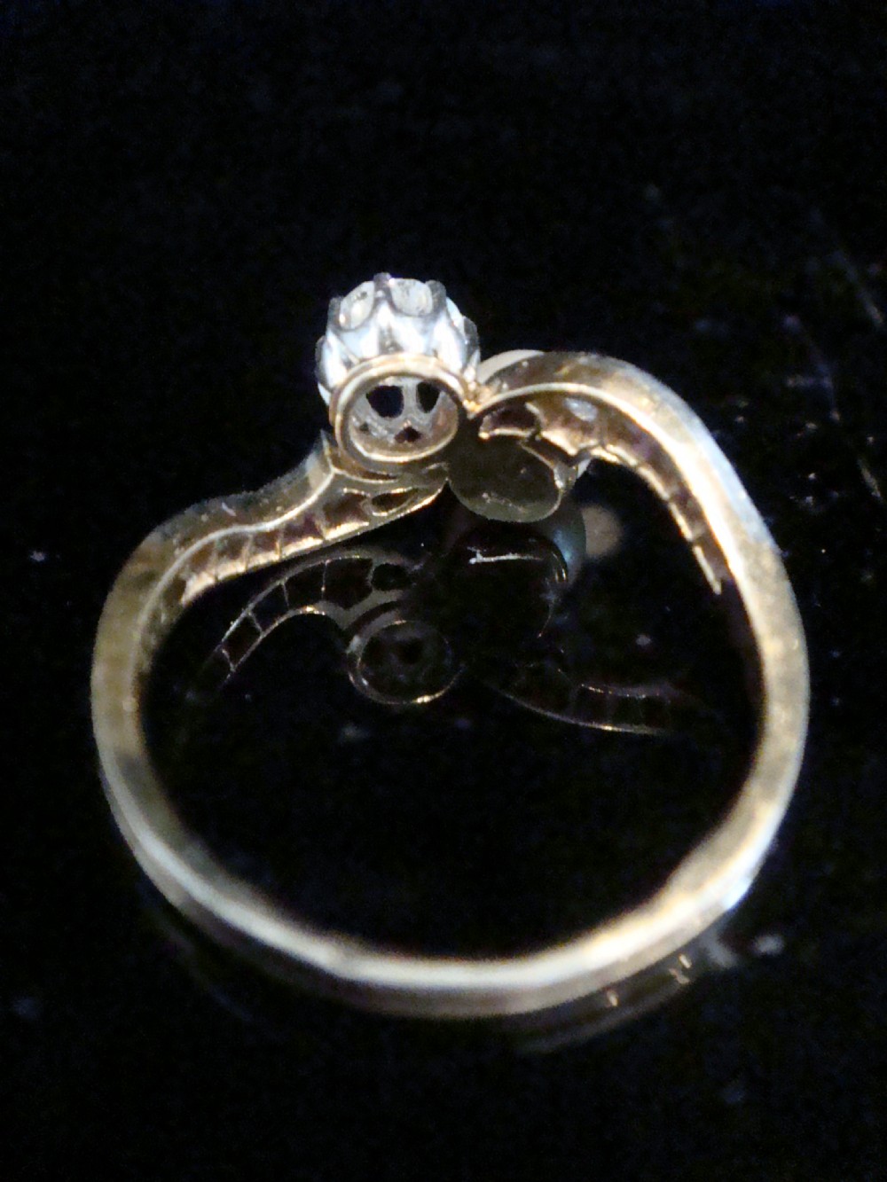 An Edwardian French 18ct yellow gold toi et moi ring set with a single cultured pearl and an old-cut diamond on a curved bypass band with accent diamonds. View III