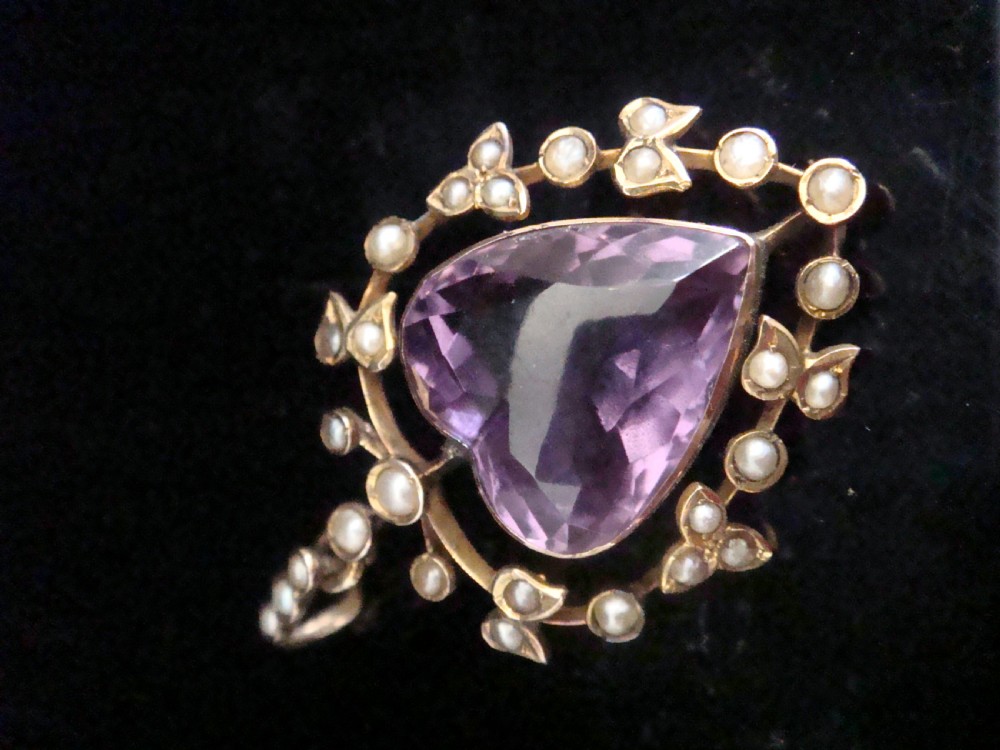 An Edwardian yellow gold heart-shaped pendant featuring a central faceted heart amethyst bordered by small seed pearls. View III