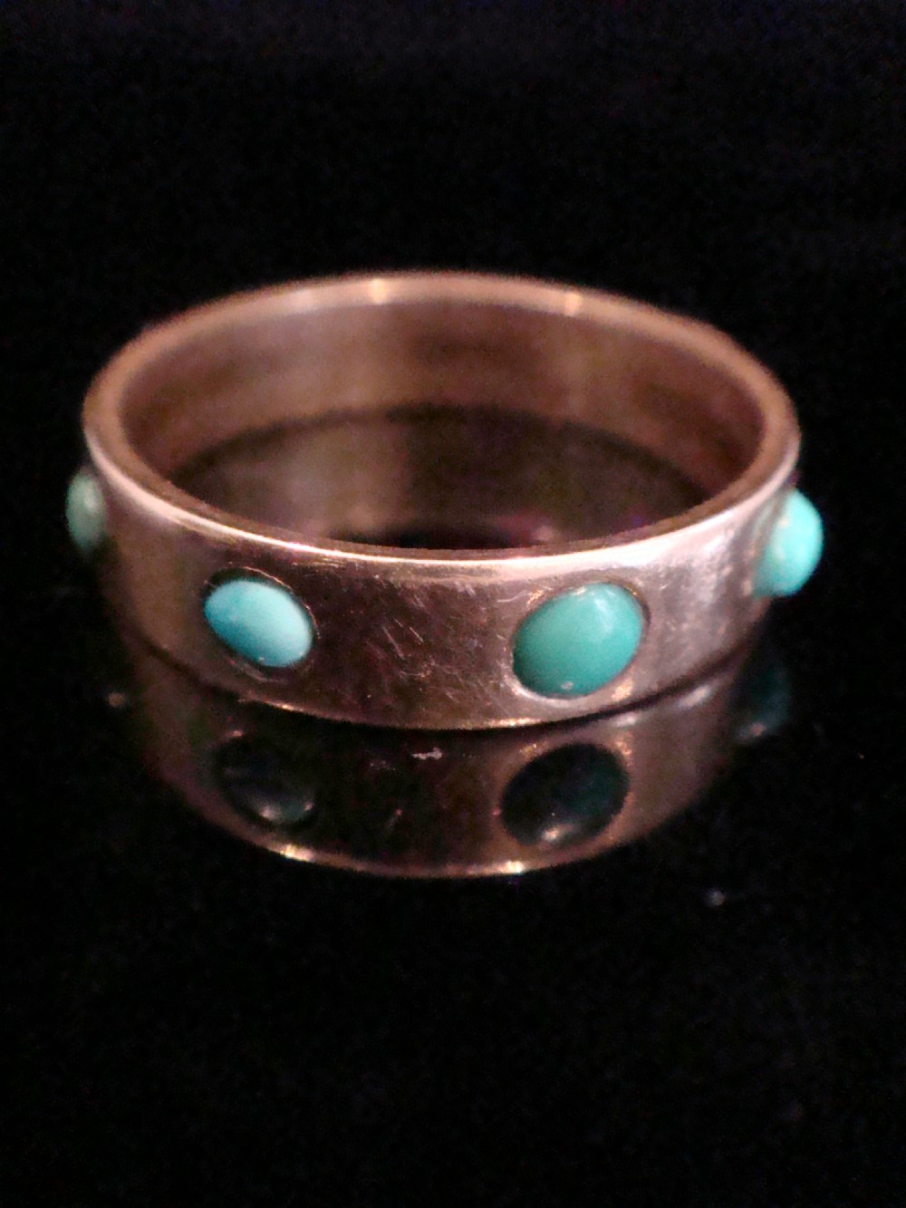 An Edwardian nine-carat rose gold full eternity ring set with smooth cabochon turquoise stones.