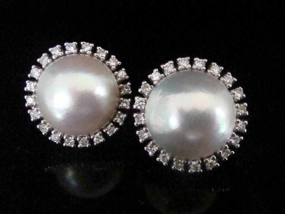 A pair of round Retro 14ct gold Mabe pearl cluster earrings encircled by a border of small brilliant-cut diamonds.