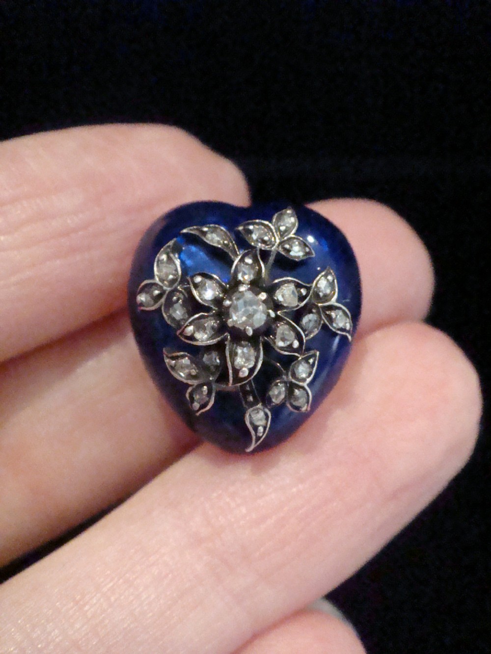 A Victorian cobalt blue guilloche enamel heart-shaped puff pendant set with a diamond floral spray.