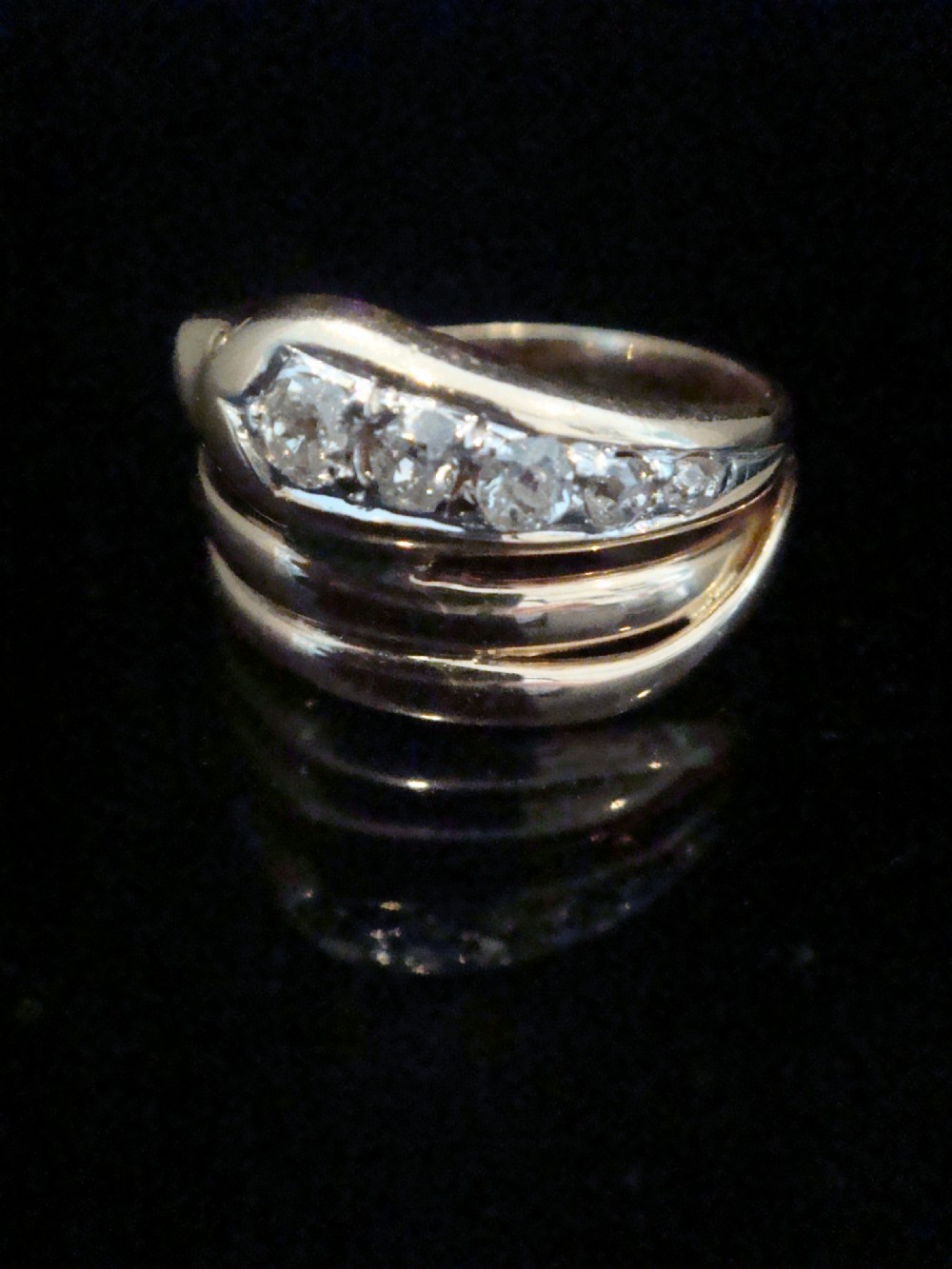 A Victorian 18ct gold snake ring featuring a coiled band set with a line of five graduated old cut diamonds along the serpent head.