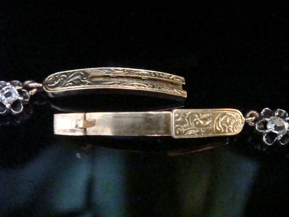 Victorian silver and gold link bracelet set with a row of flower-shaped cluster links containing round diamonds. View III