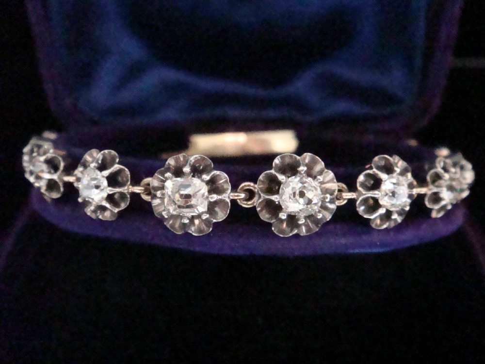 Victorian silver and gold link bracelet set with a row of flower-shaped cluster links containing round diamonds. View II