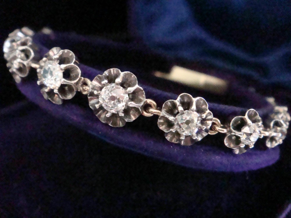 Victorian silver and gold link bracelet set with a row of flower-shaped cluster links containing round diamonds. View VI