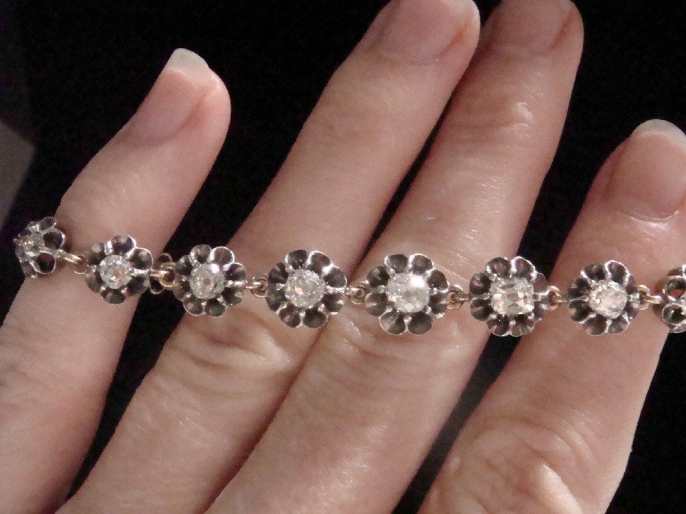 Victorian silver and gold link bracelet set with a row of flower-shaped cluster links containing round diamonds. View VIII