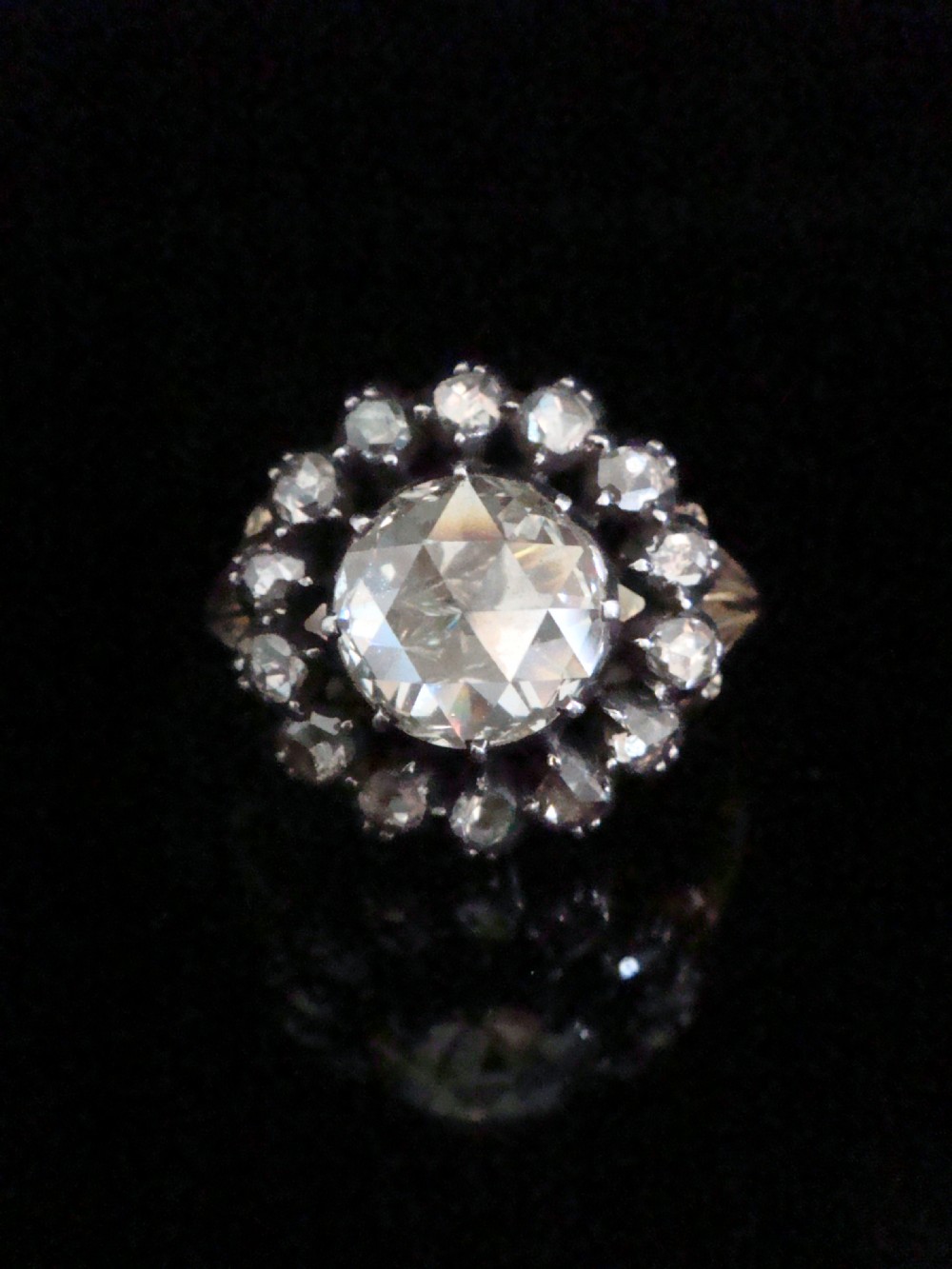 A Victorian 18ct yellow gold cluster ring featuring a central rose-cut diamond surrounded by a halo of smaller diamonds.