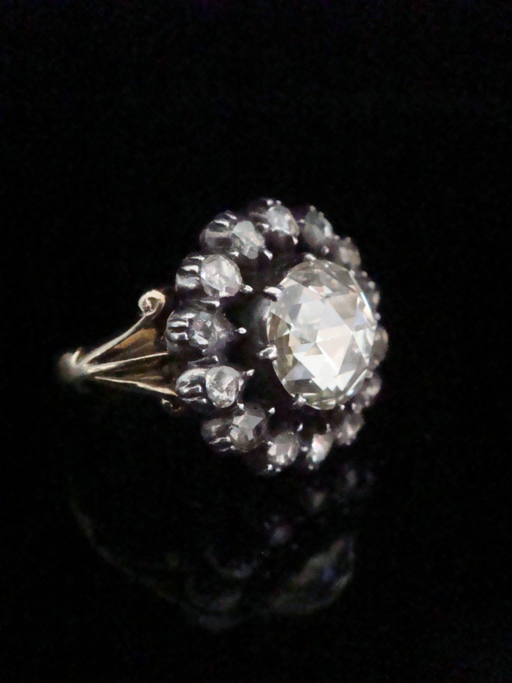 A Victorian 18ct yellow gold cluster ring featuring a central rose-cut diamond surrounded by a halo of smaller diamonds. View II