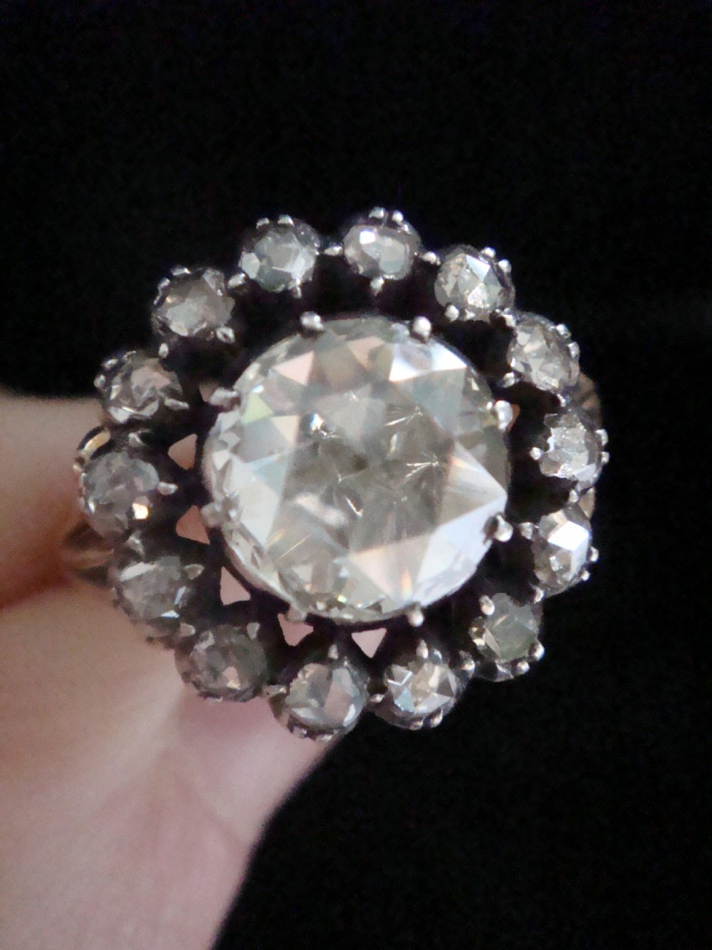 A Victorian 18ct yellow gold cluster ring featuring a central rose-cut diamond surrounded by a halo of smaller diamonds. View V