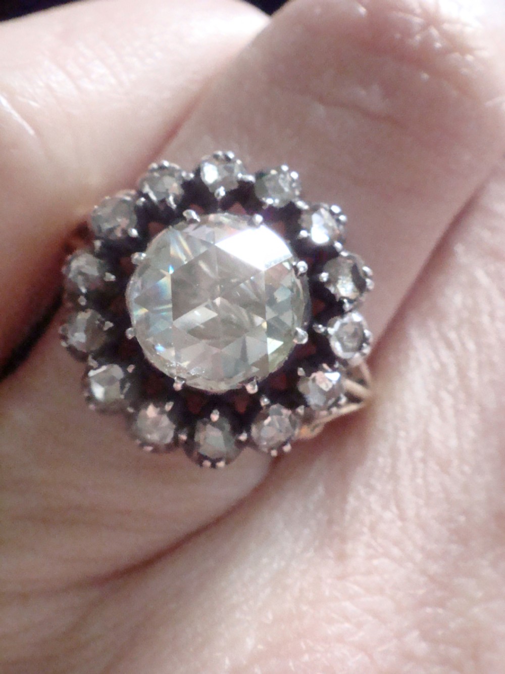A Victorian 18ct yellow gold cluster ring featuring a central rose-cut diamond surrounded by a halo of smaller diamonds. View X