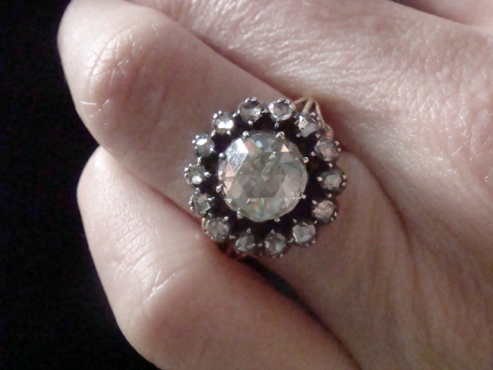 A Victorian 18ct yellow gold cluster ring featuring a central rose-cut diamond surrounded by a halo of smaller diamonds. View XI