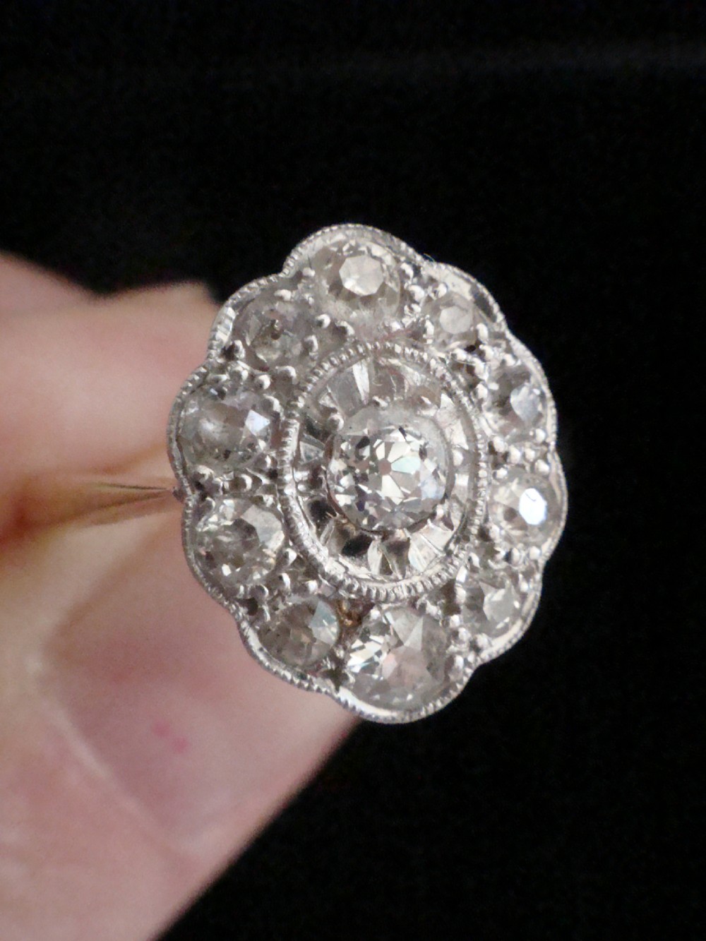 An Edwardian 18ct yellow gold and platinum ring featuring a scalloped cluster head pave-set with old cut diamonds and millegrain detailing. View III