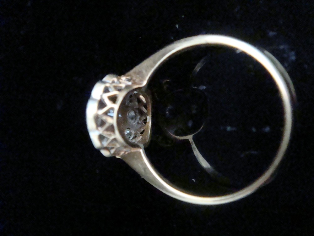 An Edwardian 18ct yellow gold and platinum ring featuring a scalloped cluster head pave-set with old cut diamonds and millegrain detailing. View IV
