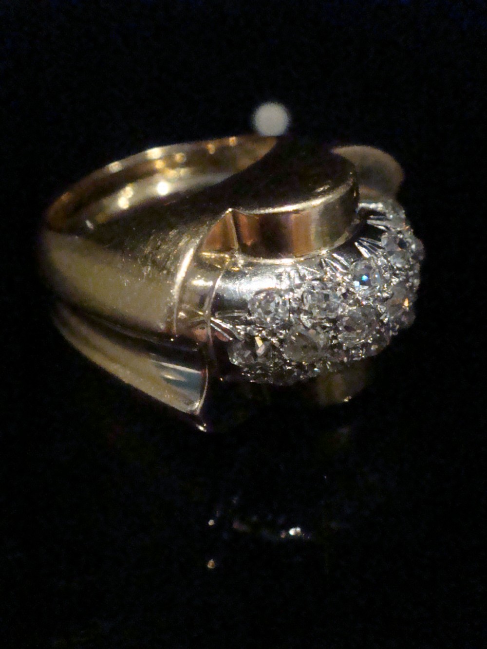 A French Retro Tank ring crafted in gold and platinum with a central pave-set diamond cluster. View IX